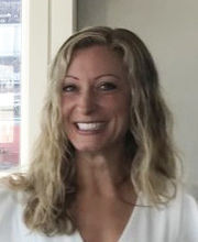headshot photo of Amanda Barudin Carreiro smiling with long wavy dirty blonde hair wearing a v-neck white top